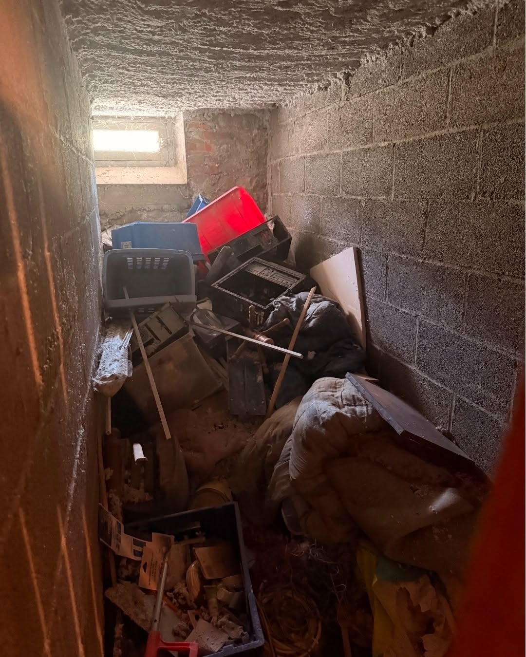 Cave encombrée de cartons, de meubles et d'objets empilés avant un débarras