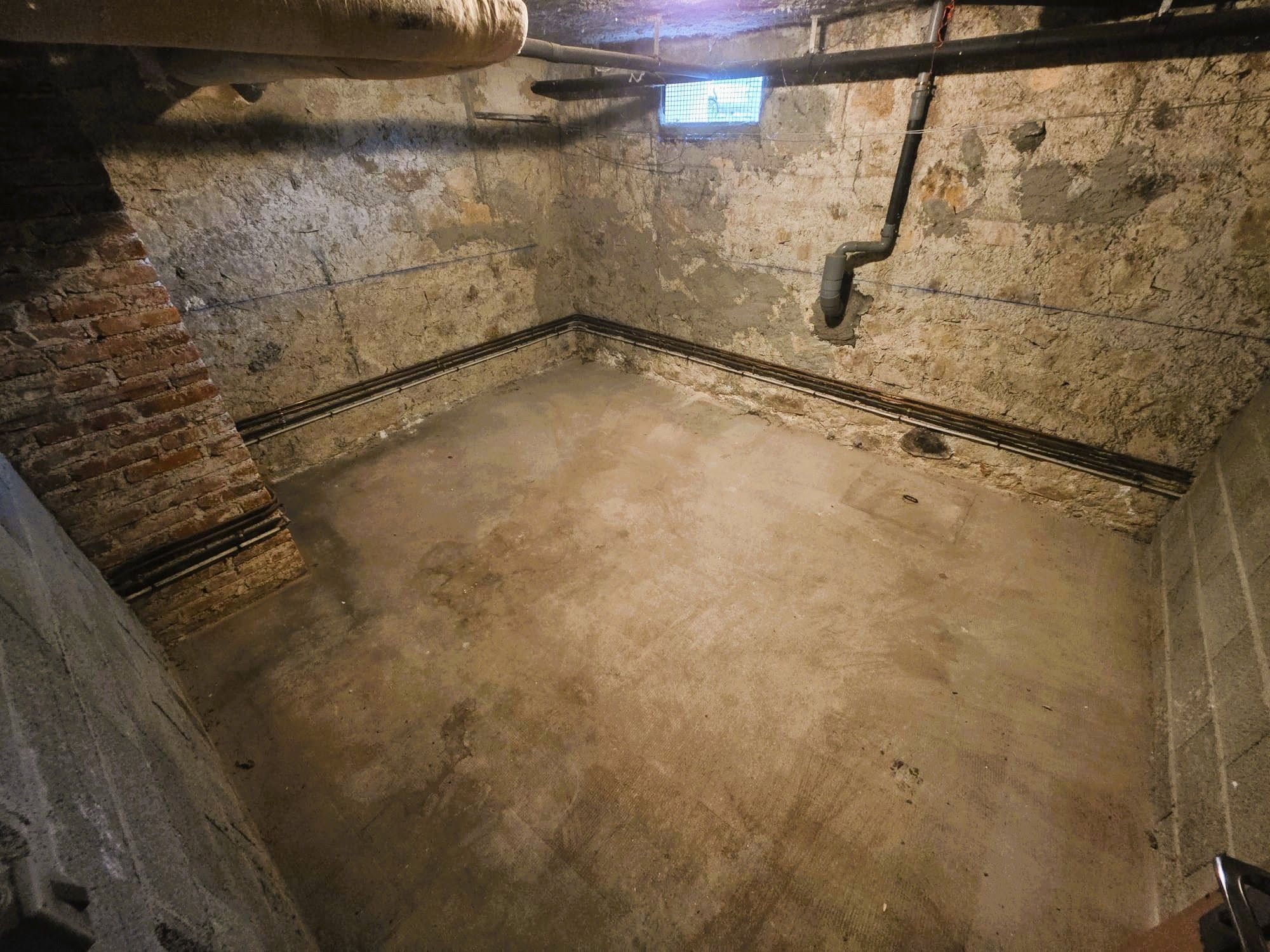 Cave vide après un débarras complet, sol balayé et volume de nouveau accessible